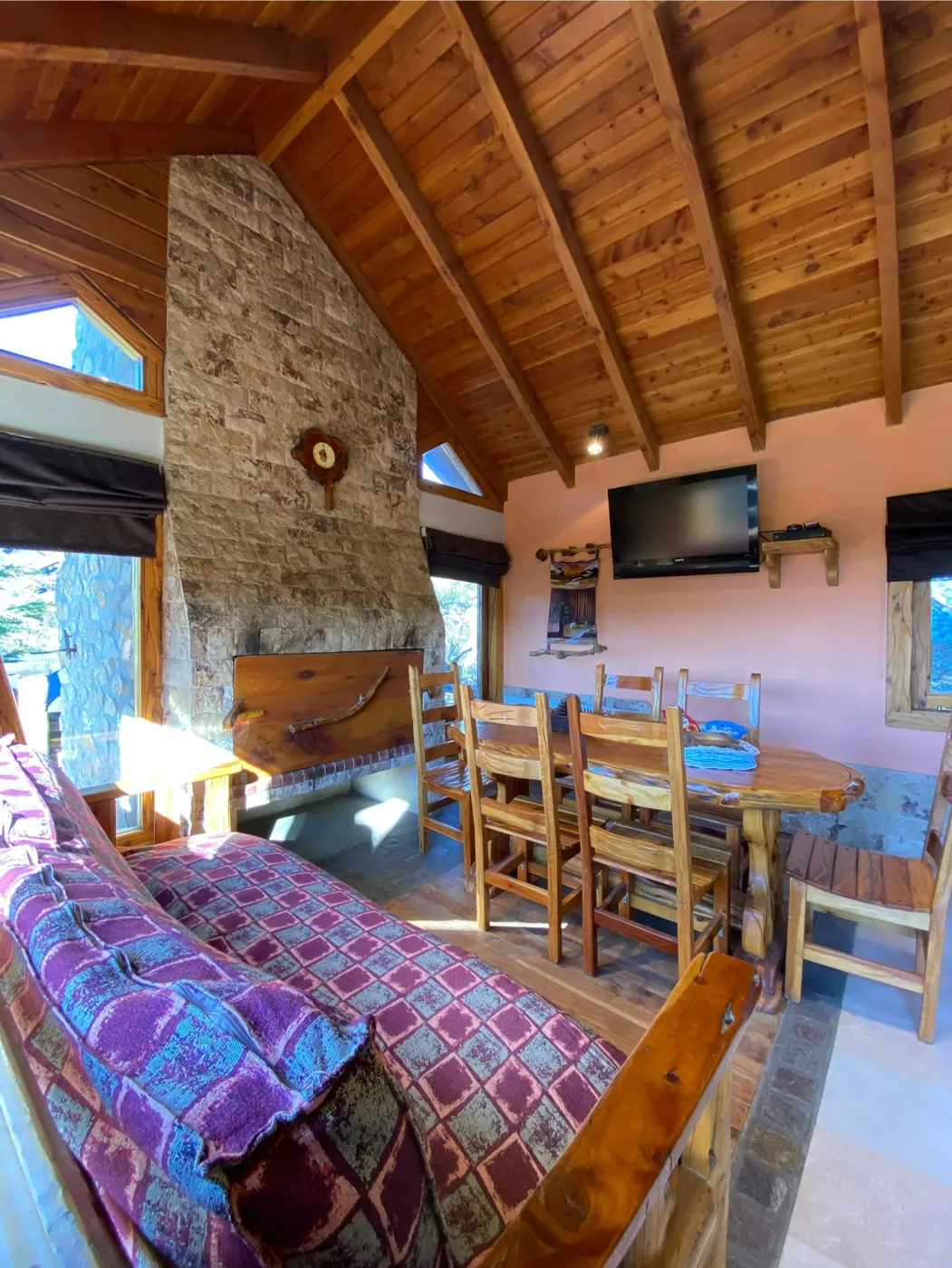 Living y comedor de la cabaña Lihuen con techo de madera